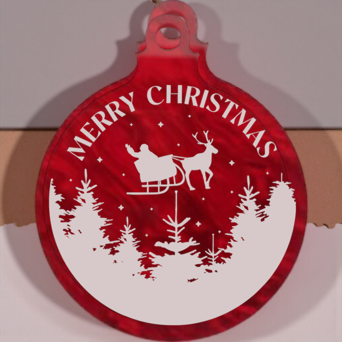 Red Christmas ornament with 'Merry Christmas' and reindeer design on a white background