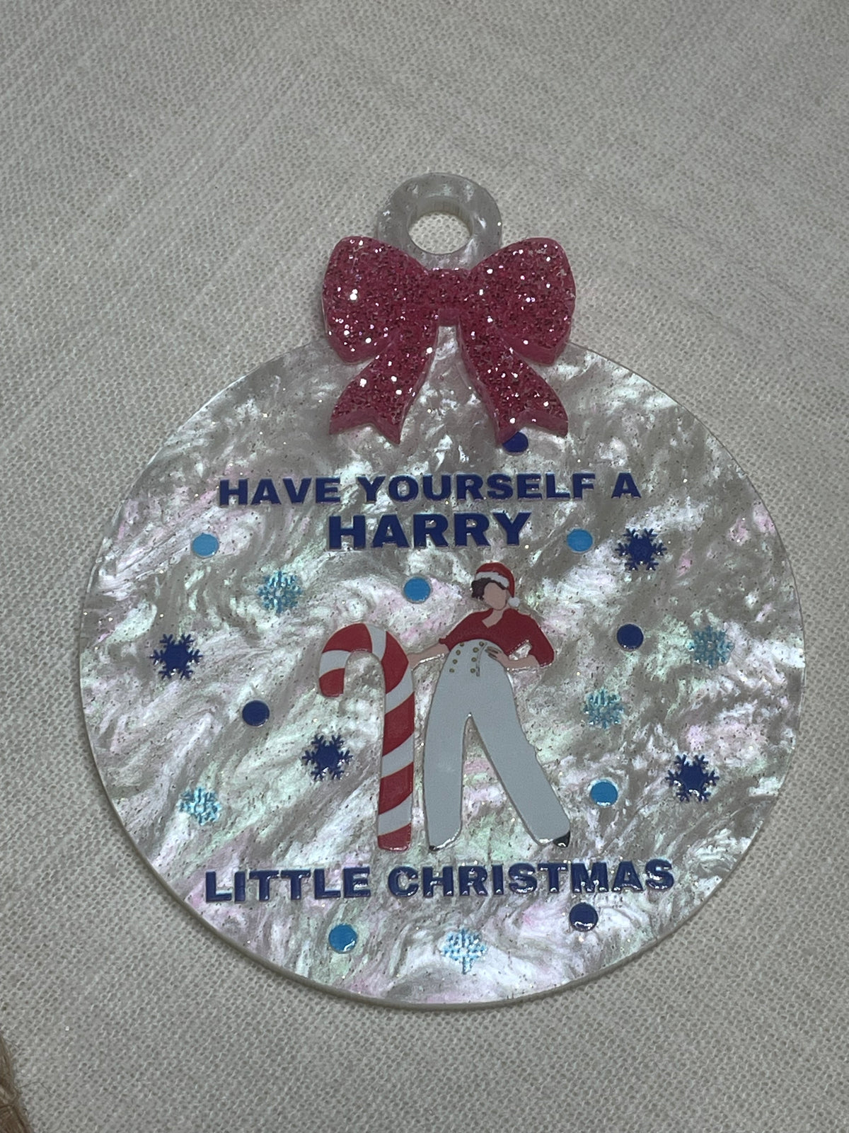 Circular Christmas decoration with text and festive design on a textured surface