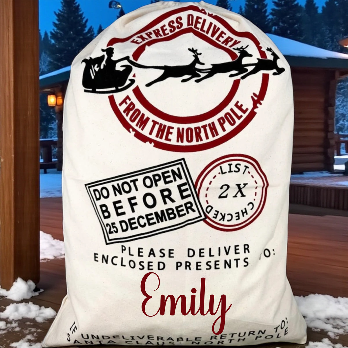 Decorative Santa sack with festive text in front of a wooden cabin in a snowy landscape.