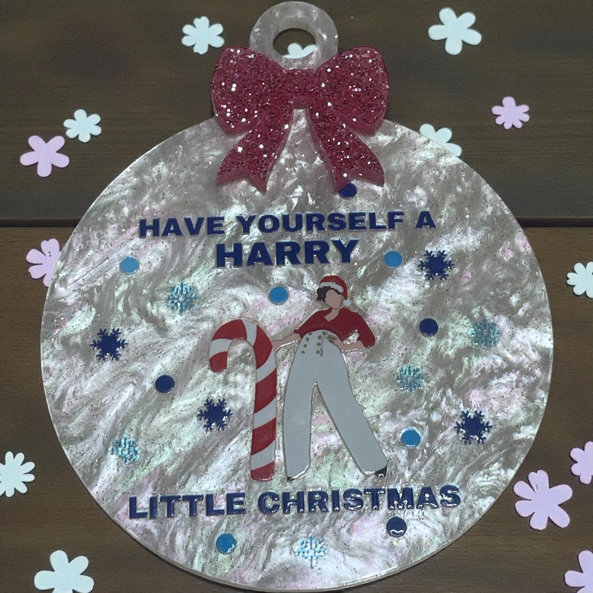 Decorative Christmas ornament with text and graphics on a wooden background