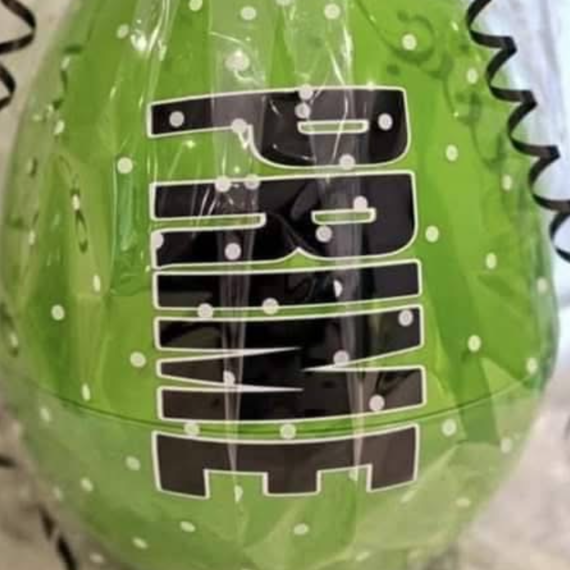 Green ball with black text and a black and green ribbon on a light background