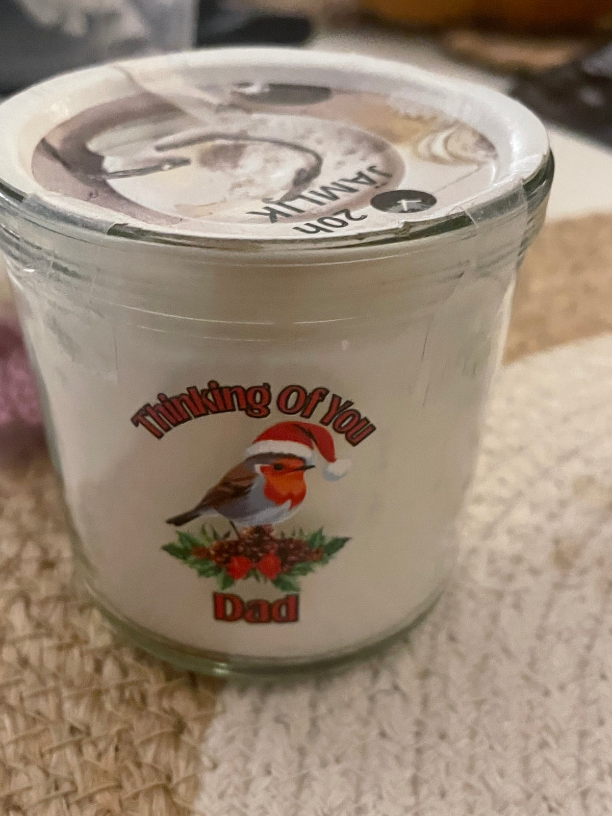 Clear container with a label featuring a bird and text on a textured surface