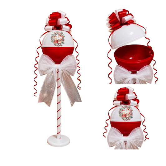A red and white Christmas ornament display stand featuring a candy cane pole, a large white and red ornament with a white tulle bow, and a small wreath emblem. Two smaller inset views on the right show the ornament from different angles, including an open top view revealing a red bowl inside.