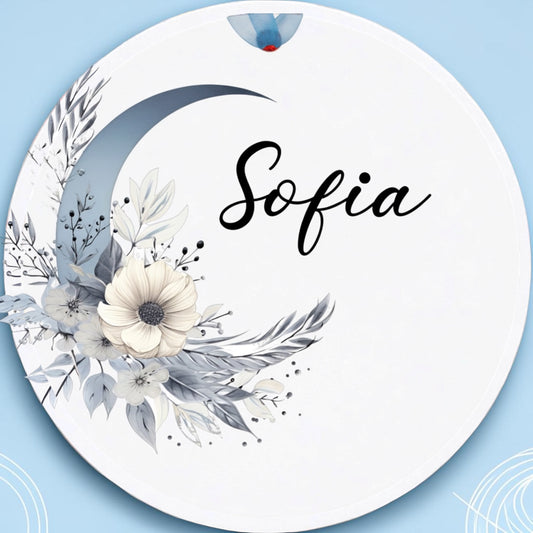 Circular decorative item with floral design and 'Sofia' text on a light blue background