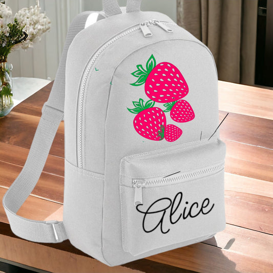 A white personalized rucksack featuring a strawberry print, with a front pocket and a name 'Alice' printed on the front.