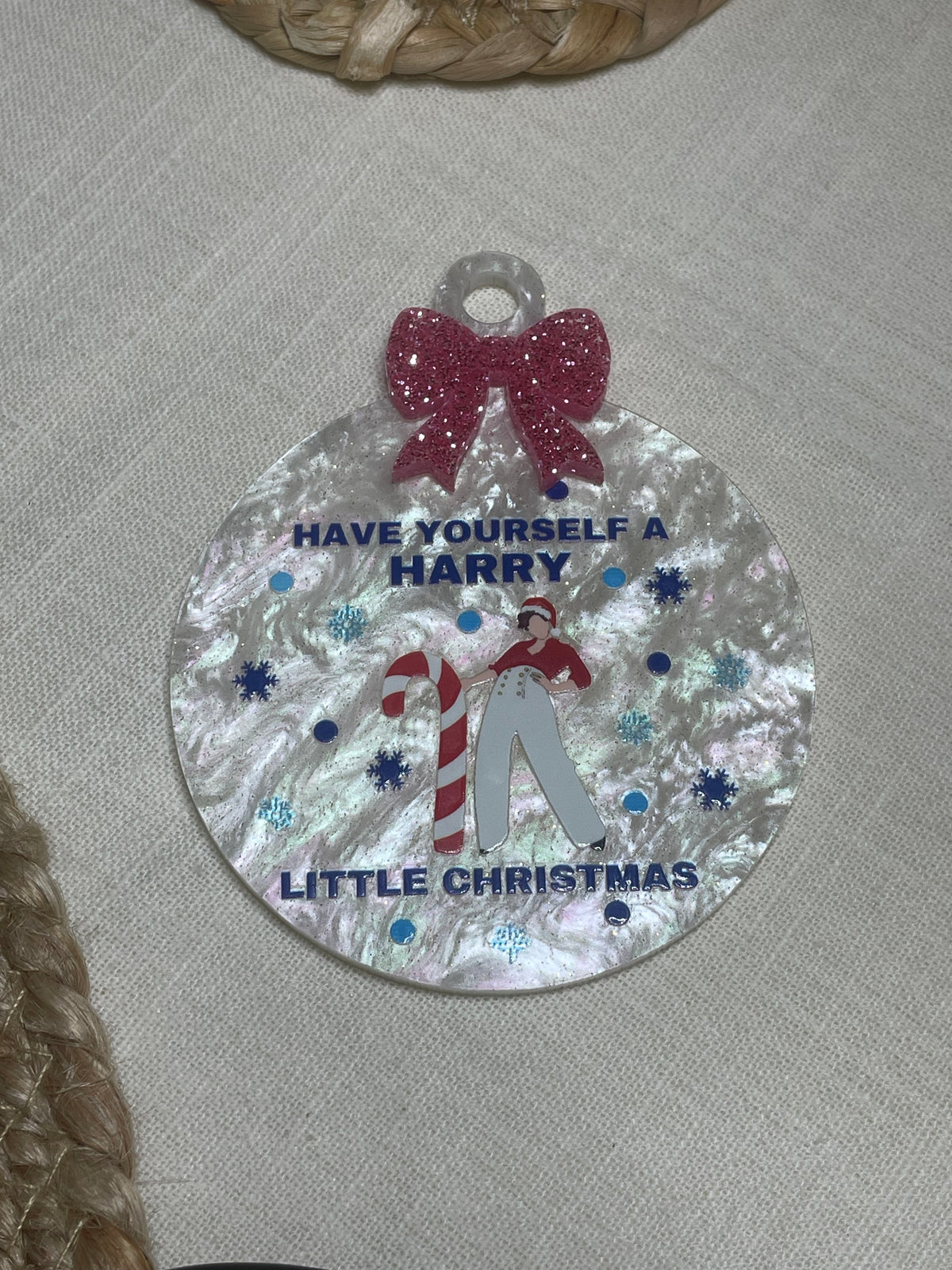 Decorative round tag with Christmas-themed text and graphics on a textured surface.