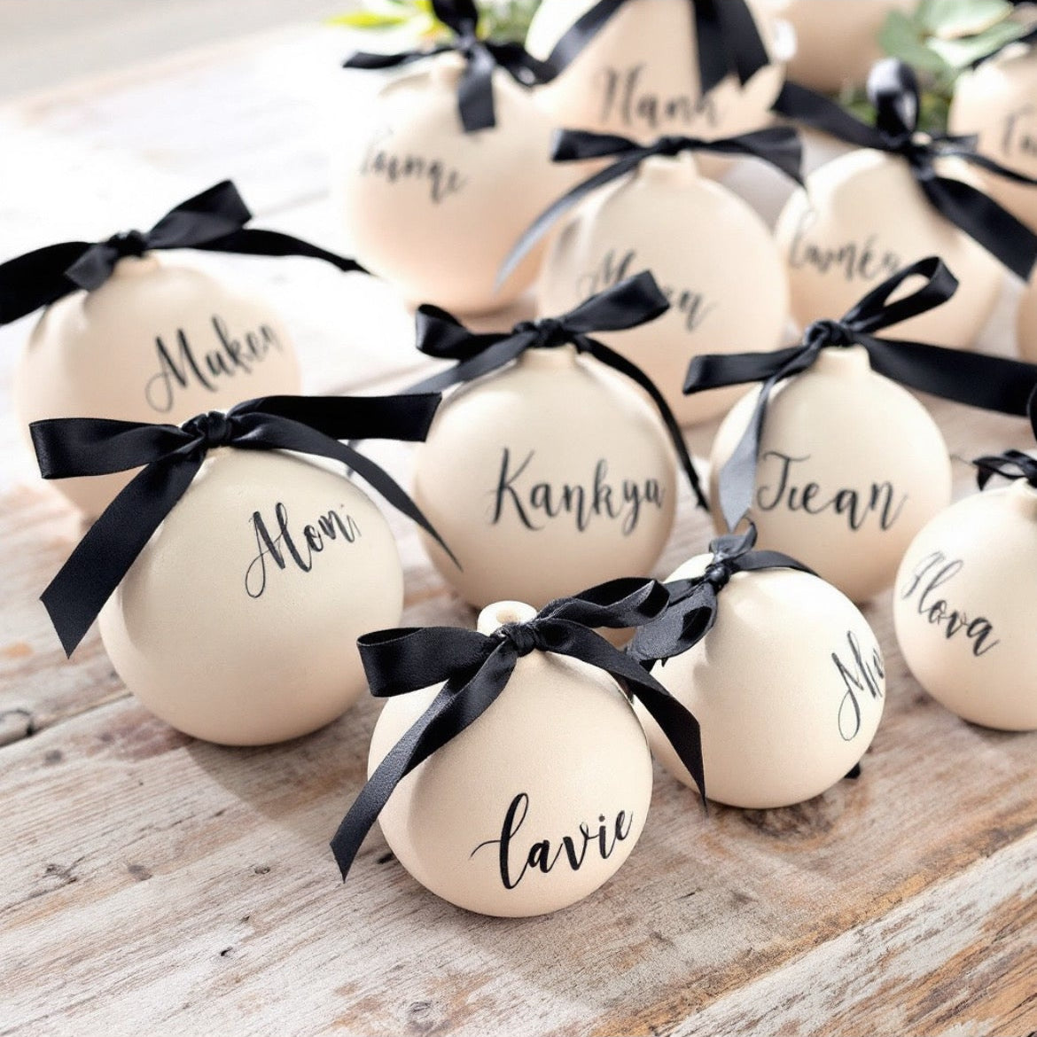 Decorative eggs with names and black ribbons on a wooden surface